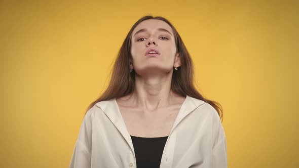 Woman Taking a Deep Breath and Exhale on a Bright Yellow Background