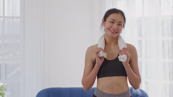 Healthy asian young woman smile resting after workout exercise at home