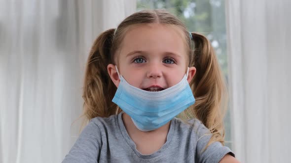 Sick Little Girl Wearing a Medical Mask Against Virus Closeup Looking at Camera