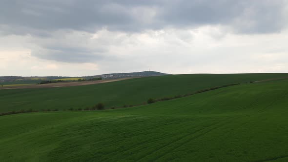 Drone footage curvy grass field. Tuscany, beautiful green field in Czechia