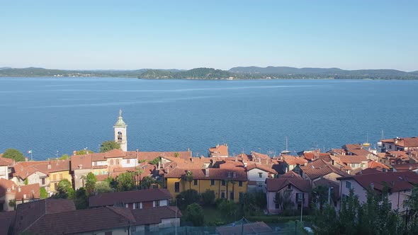 Aerial pan left panoramic view of Belgirate village on Lake Maggiore, Italy