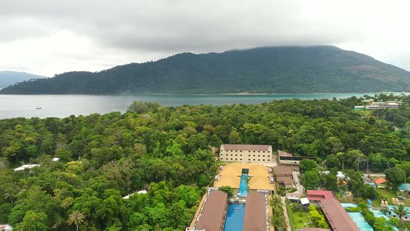 Flying Drone Aerial View to Green Tropical Island with Luxury Resorts Mountain