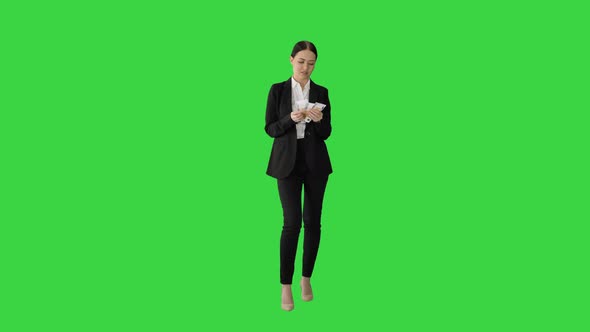 Brunette Woman Counting Euro Banknotes and Looking To Camera on a Green Screen, Chroma Key.