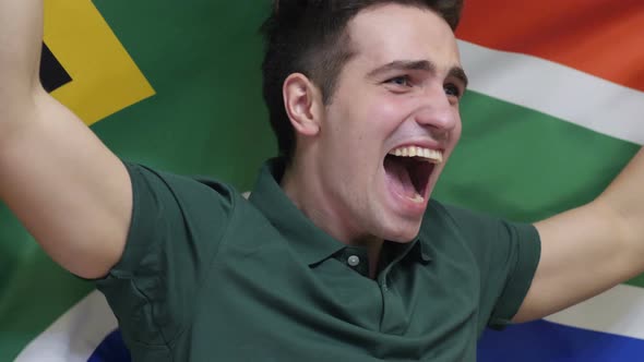 South African Young Man Celebrating while Holding the Flag of South Africa