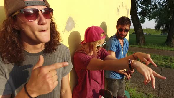 Close up of cheerful young skateboarders singing and dancing