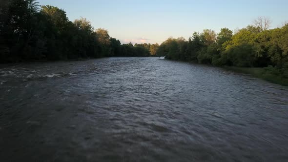 Drone shot flying low and fast over a river in the evening