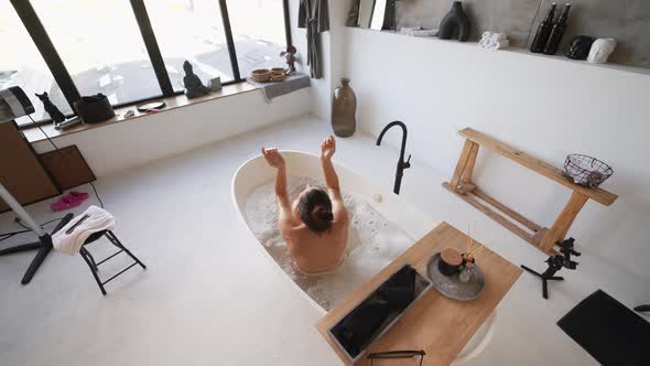 Pretty Young Woman Taking Bath at Home Back View