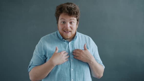 Portrait of Shy and Thankful Guy Making Thank you Hand Gesture and Touching Face