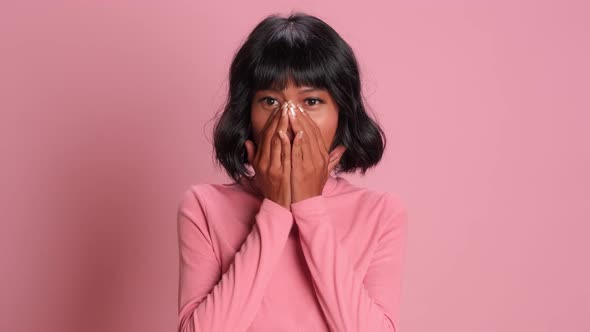 Shocked African American Woman Covers Face with Hands While on Pink Background