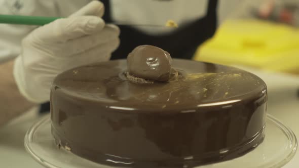 Professional chef throwing gold dust on the chocolate cake