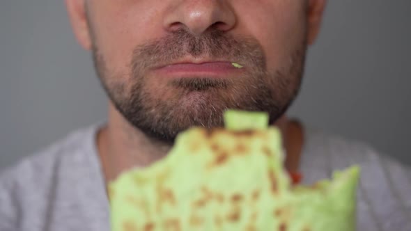 Man Eating Spinach Shawarma with Chicken and Vegetables Close-up