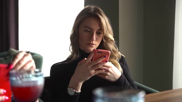 A Woman Typed a Message on Her Smartphone in a Modern Cafe.