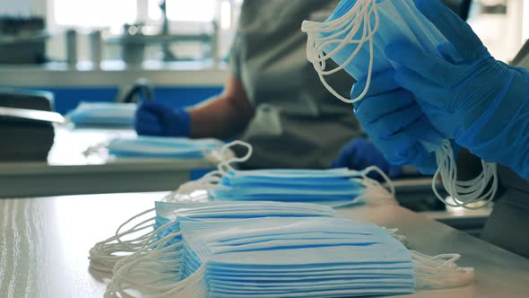 Female Medical Worker Counting and Stacking Face Masks. Close Up