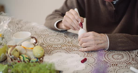 Senior Man Painting Easter Egg