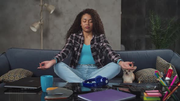 Relaxed Female Meditating in Lotus Posture During Work