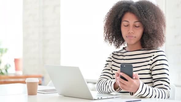 Woman with Laptop Using Smartphone