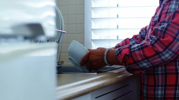 Senior woman washing utensils at home