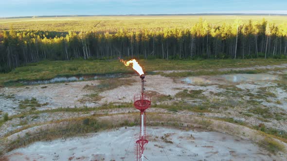 A Drone Flies Around a Burning Torch at an Oil Field in the Swamps of Siberia