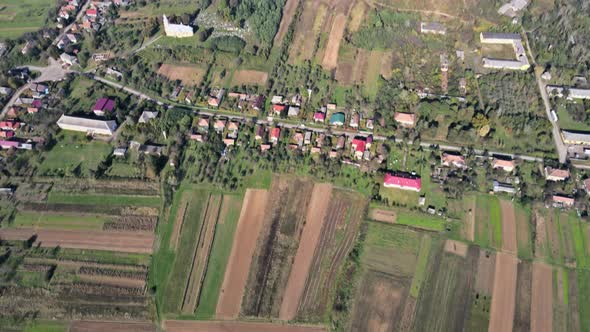 Aerial Panorama in Springtime Field on Hillside Mountains Near Village in Wonderful Landscape