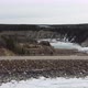 Aerial fly over edge of frozen dam with logging truck passing by - VideoHive Item for Sale