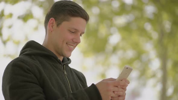 Cheerful Young Man Using Cell Phone Outdoor