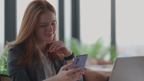 Young Businesswoman Use Smart Phone with Laptop