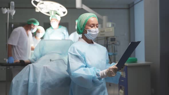 Woman in Mask and Uniform Hold Digital Tablet of Patient Diagnosis, Check, Looks Up