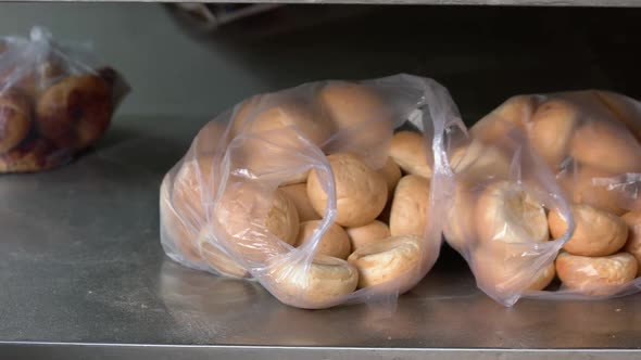 Round Bread Buns in Plastic Bags on Baking Tray in Bakery