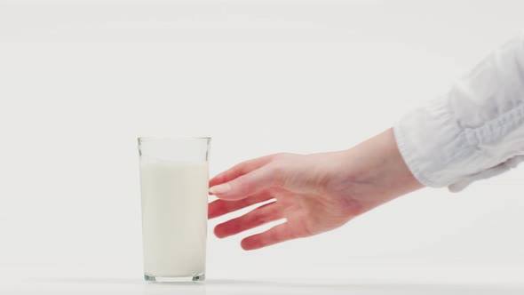 Hand taking a glass of milk