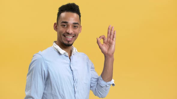 Portrait of Smiling Arabic Guy with Beard and Mustache Showing OK or Alright Sign on Camera Isolated