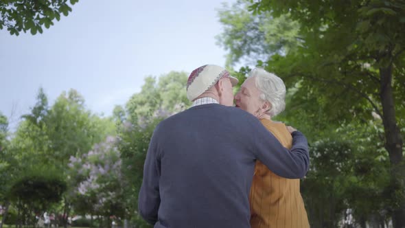 Portrait Mature Couple in Love Sitting on a Bench in the Park. Adult Woman and Old Man Together