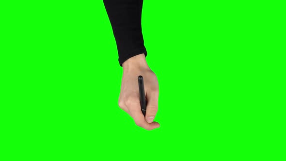 Male Hand in a Black Sweater with Liner Pen Is Writing on Green Screen Background. Close Up