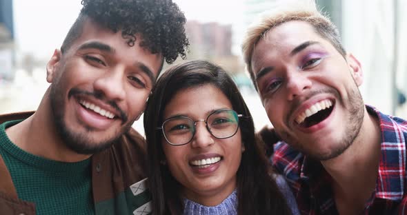 Young diverse friends smiling on camera outdoor