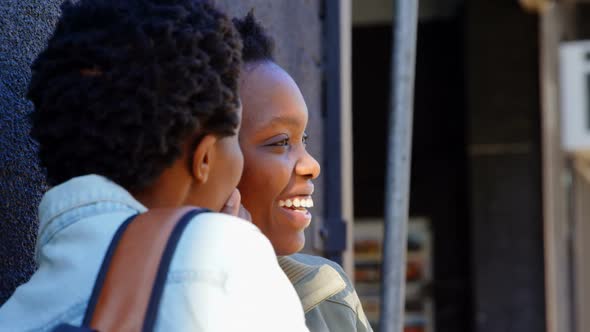 Twin sisters gossiping with each other in the city 4k