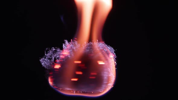 Fire burning on steel wool as it is spinning while floating. alt