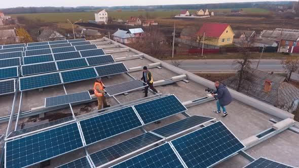 Workers Put New Solar Battery on Roof. 
