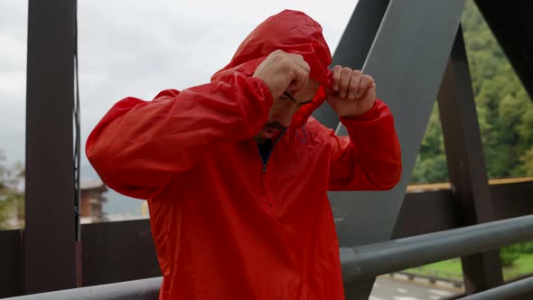 a Man in a Red Jacket Has Arms Crossed Over Chest and is Standing