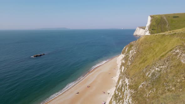 People relaxing at Durdle Door beach in Dorset, England. Aerial drone view