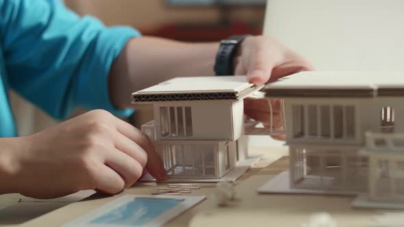 Close Up Of Hand's Man Engineer Making Paper Model Of House At The Office