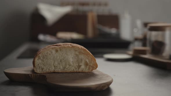 Slow Motion Man Slciing Fresh Ciabatta on Olive Wood Board