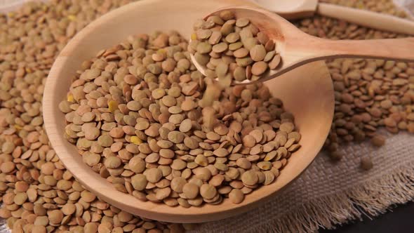 Dry Green Lentils in a Wooden Bowl on the Table Closeup