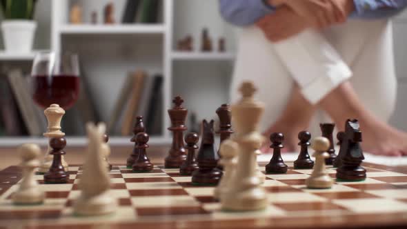 The Girl Plays Chess Sits On The Background Of Chess Pieces Chess Game Board Figures In The Unfolded