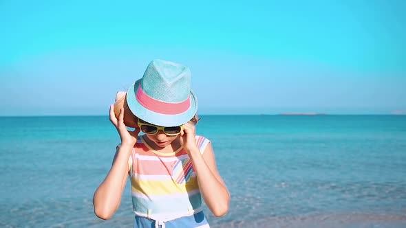 Happy Child Listen Seashell on the Beach