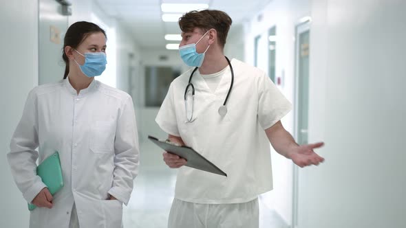 Portrait of Confident Intelligent Positive Doctors Walking in Hospital Corridor Talking