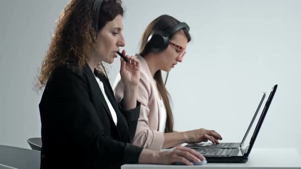 Customer Support Agent or Call Center with Headset Works on Desktop Computer While Supporting the