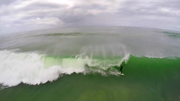 Aerial view of a surfer riding a wave while surfing