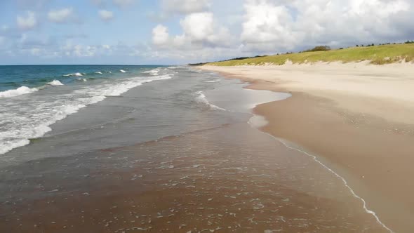 AERIAL: Flying Backwards and Revealing Golden Sand Beach on a Sunny Day, Slow Motion, High Speed Cam