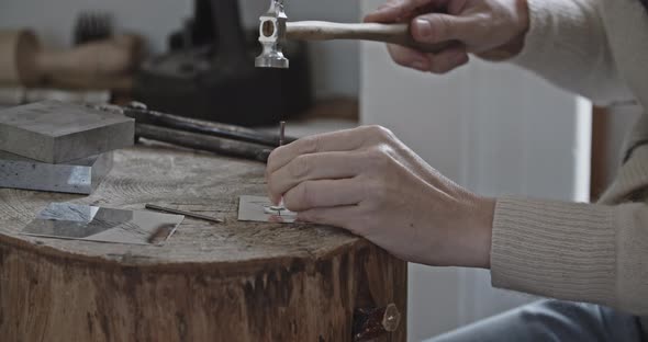 Goldsmith hammering out a stencil