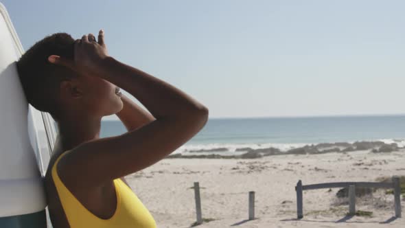 Young adult woman leaning on a van relaxing by the sea 4k