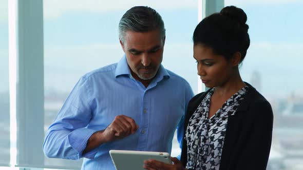 Executives discussing over digital tablet in office